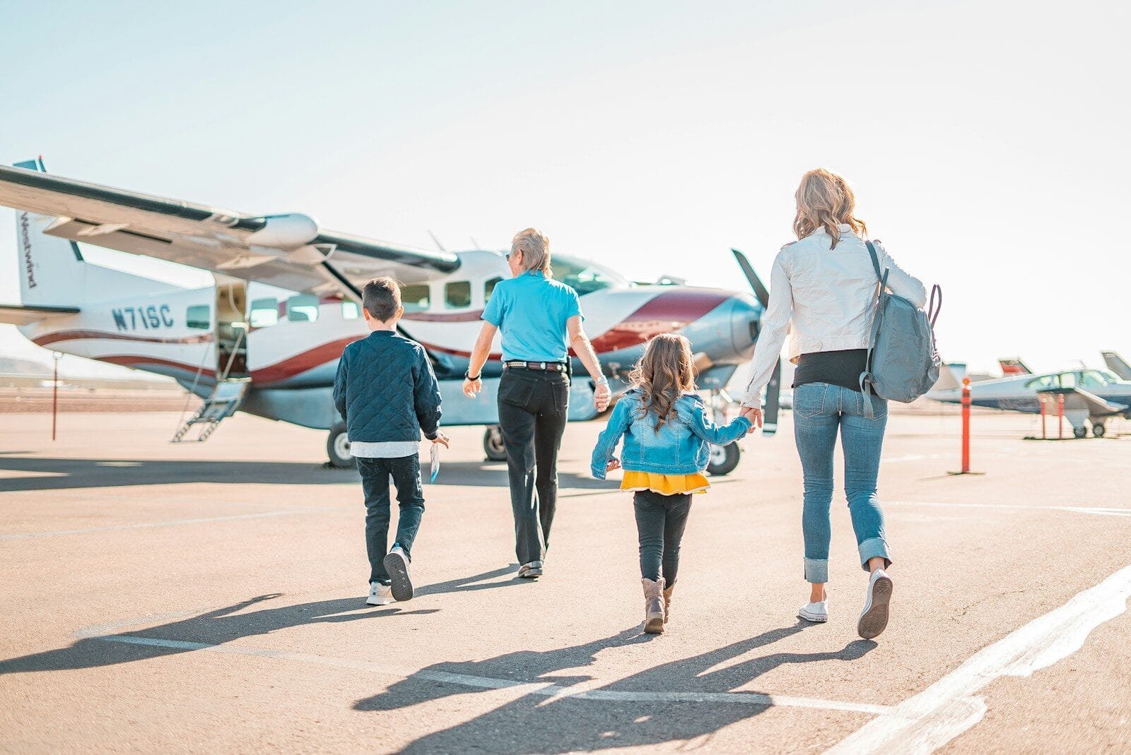 Family with children walking to a small plane for a domestic US flight