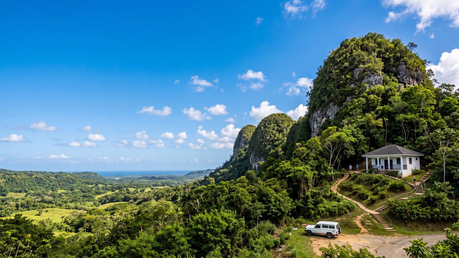 Green karst hills with steep rounded limestone mounds and a small white visitor building — Puerto Rico
