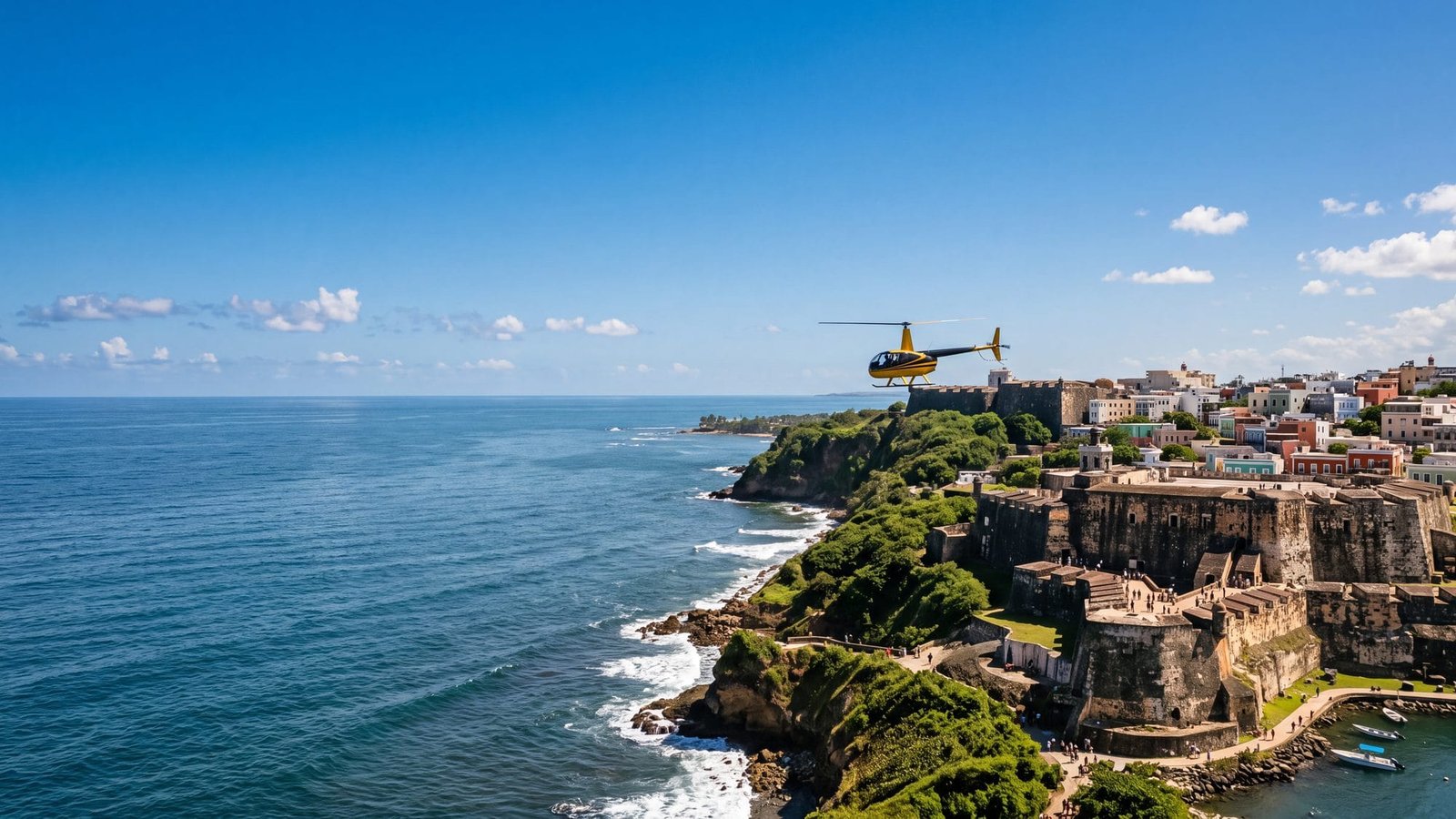 A small helicopter flying low along the coast past the old fort and walled city, seen from a nearby vantage — Puerto Rico